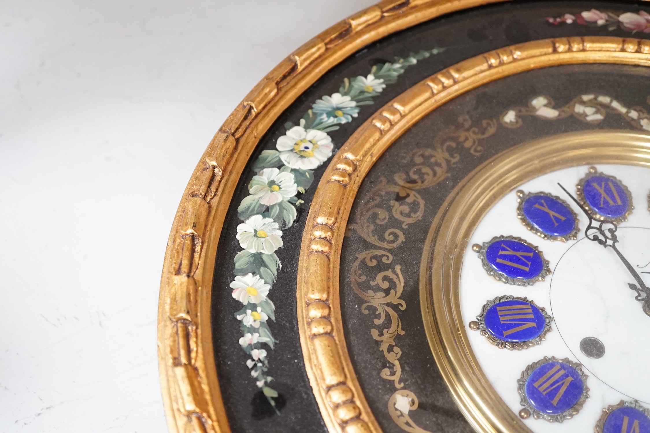 A floral painted clock, length 63cm, quartz movement